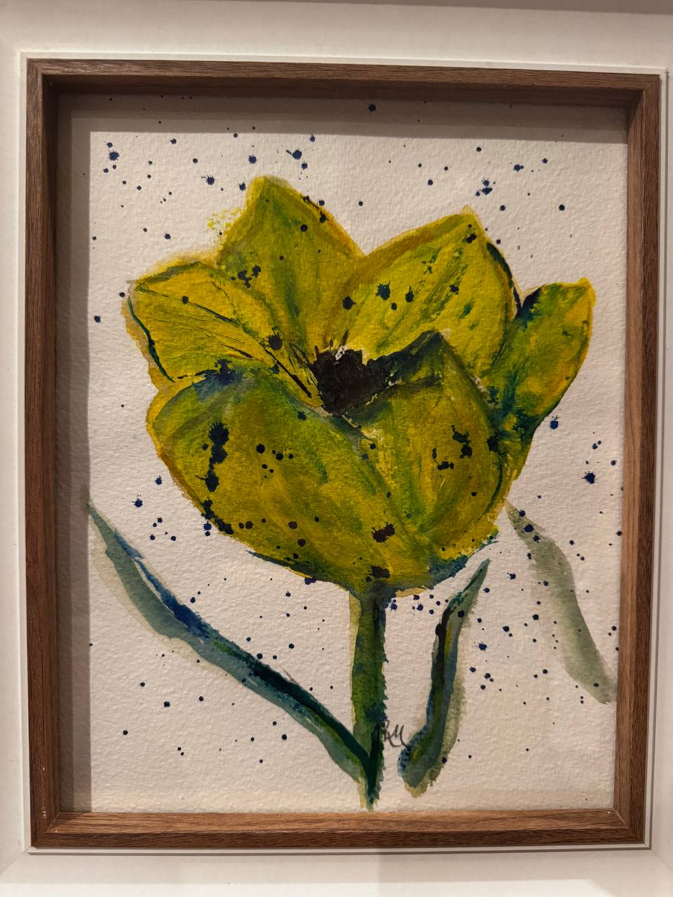 Expressive yellow-green tulip with deep blue splashes on pale paper